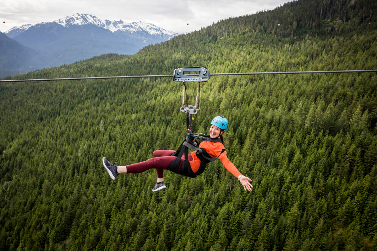 Thrill-seeker gliding on a zipline through lush treetops, with a beaming smile, capturing the joy and excitement of the experience