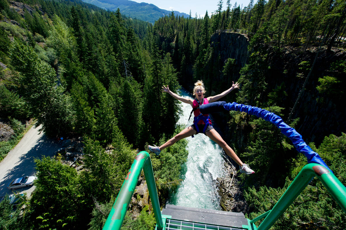 Adventurer in mid-air, bungee jumping off a bridge, arms outstretched, embracing the thrill and freedom of the moment.